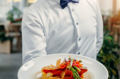 waiters holding plate grilled salmon mashed potato topped with red caviar asparagus 140725 519